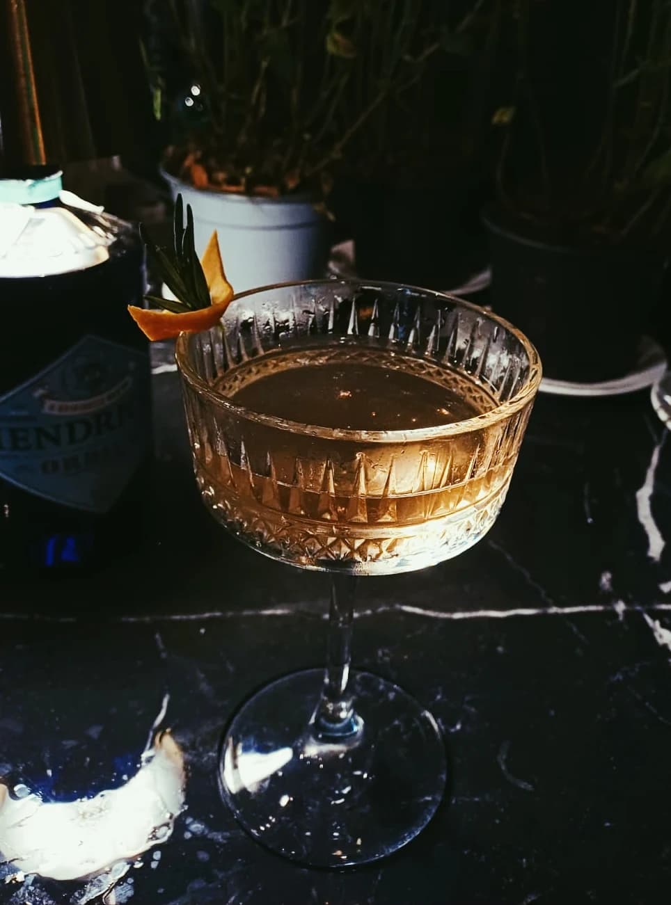 An amber cocktail served over ice