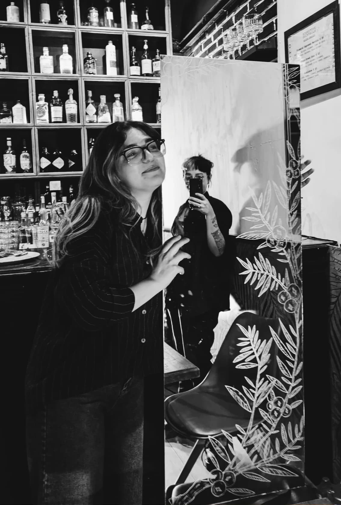 A bartender at work behind the bar, in black and white