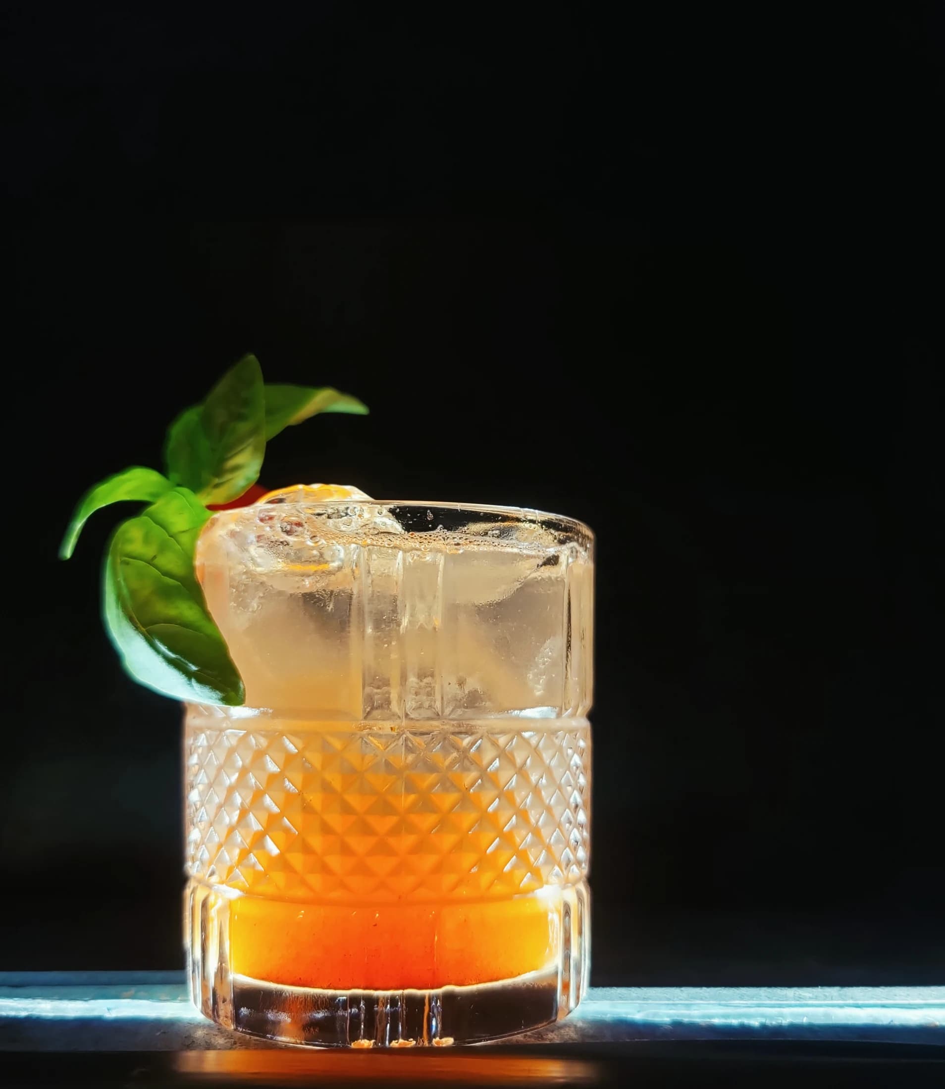 A cocktail garnished with fresh basil