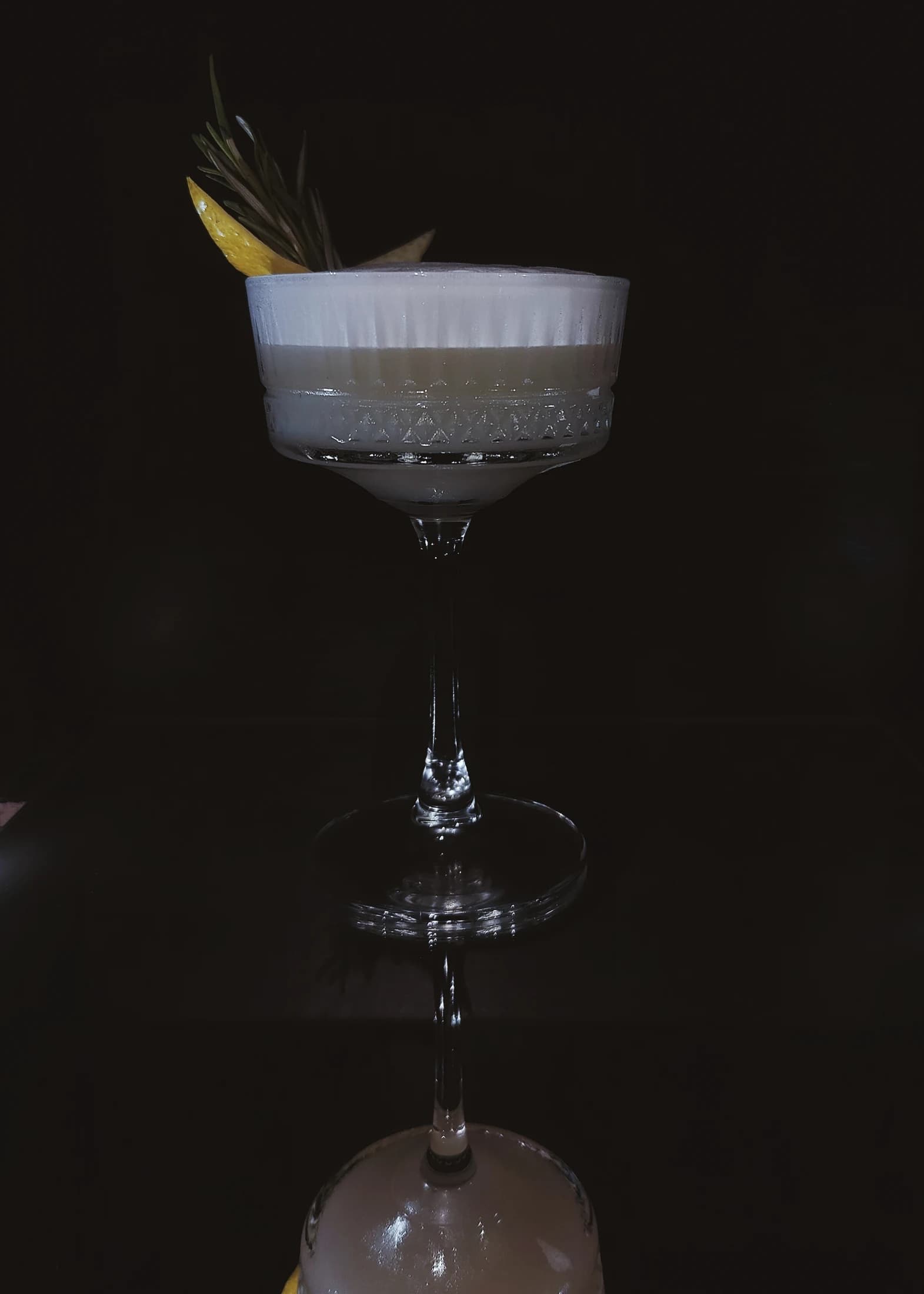 A frothy white cocktail in a coupe glass