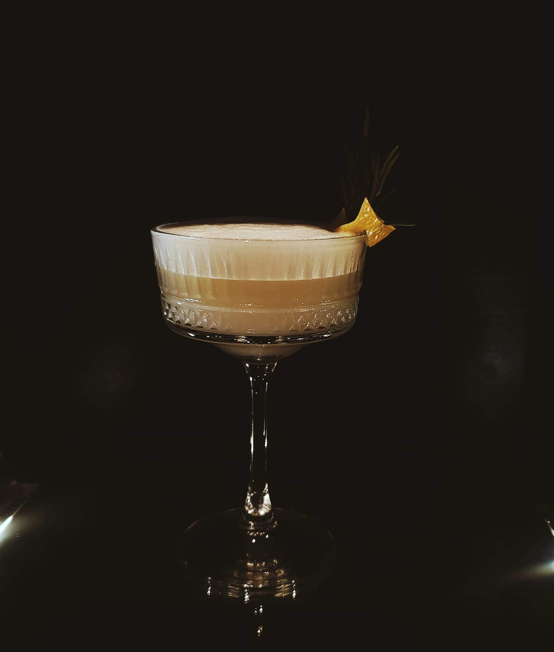 A creamy cocktail with a citrus garnish