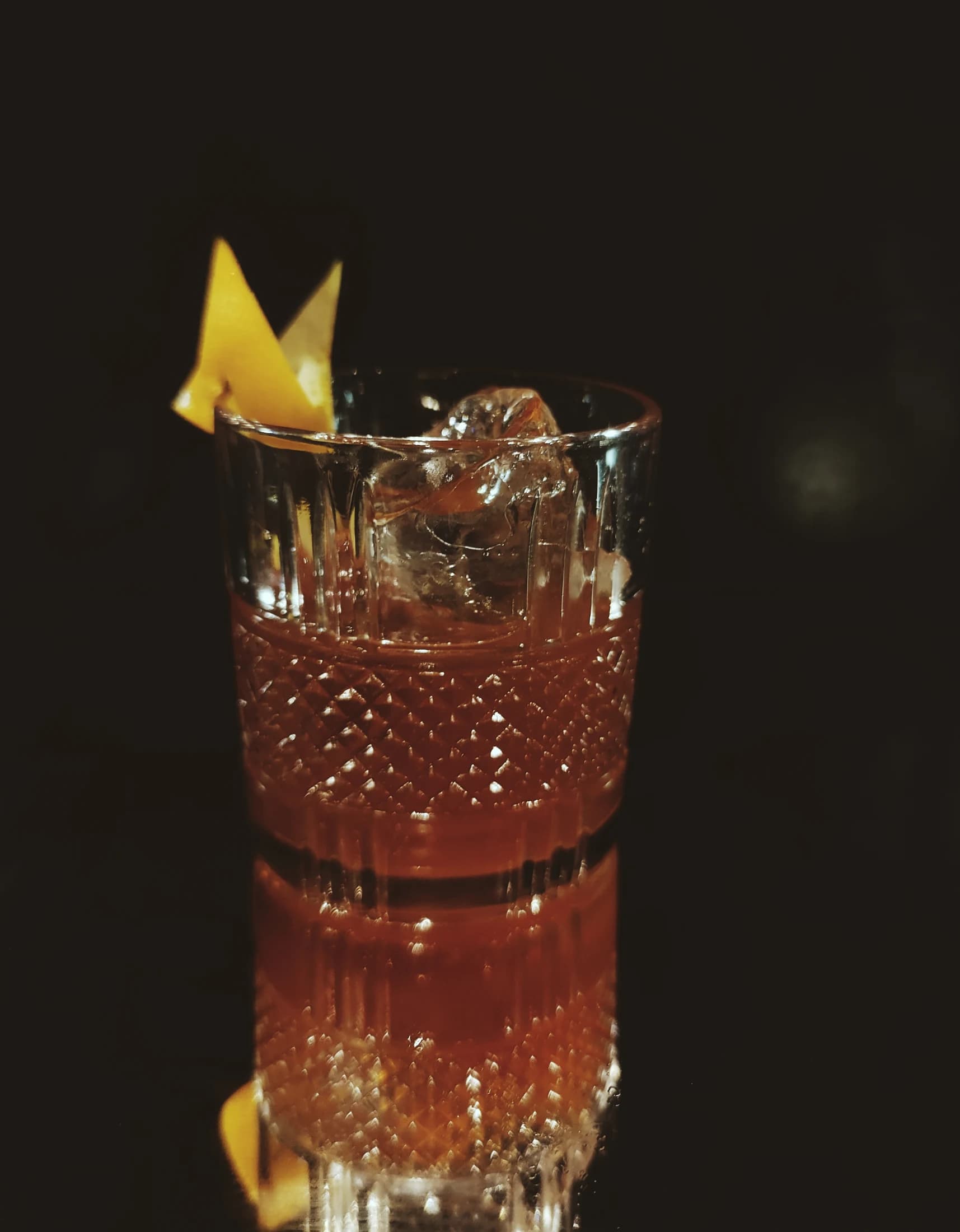 An Old Fashioned-style cocktail with a lemon twist